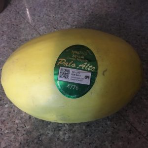 Yellow round spaghetti squash with sticker.